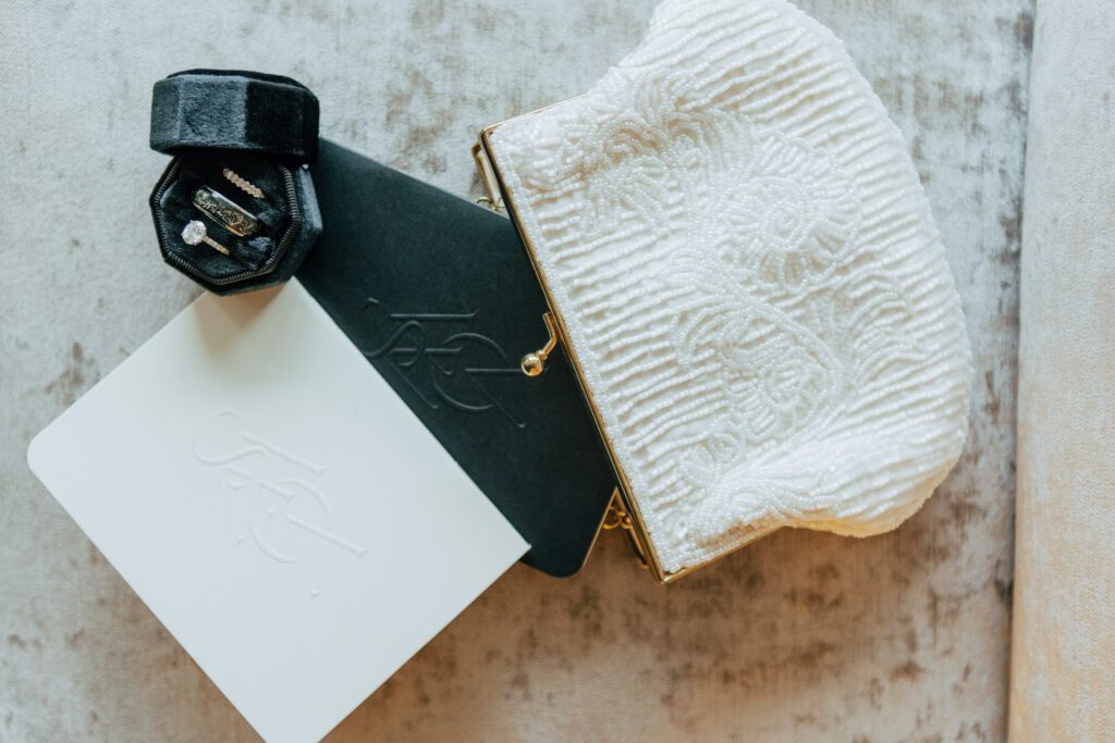 Flat lay of hand written vows and brides bag at Black Swan Country Club in Georgetown, Massachusetts.