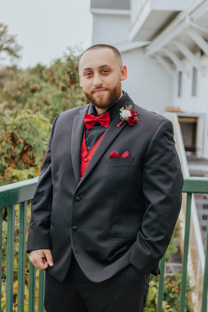 Groom getting ready outside wearing red accents at Black Swan Country Club in Georgetown, Massachusetts.