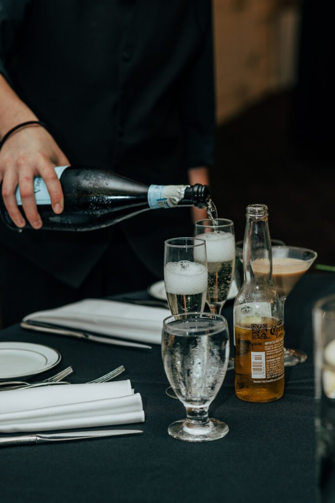 Pouring a glass of champagne during classic wedding reception at Black Swan Country Club in Georgetown, Massachusetts.