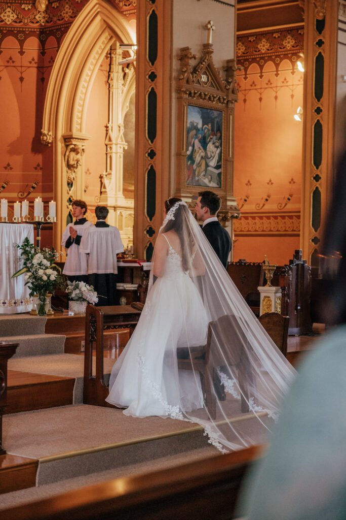Bride and groom standing at the alter at Quinet Saint John Garden of Our Lady in Massachusetts during wedding ceremony.