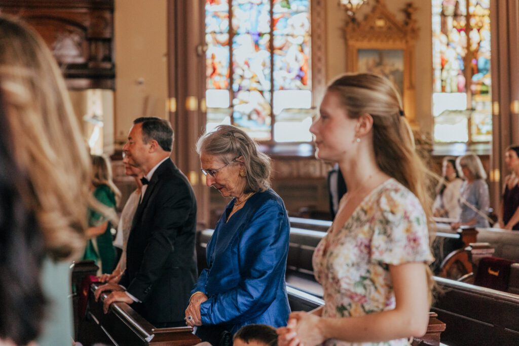 Guest praying during wedding ceremony at Quinet Saint John Garden of Our Lady in Massachusetts.