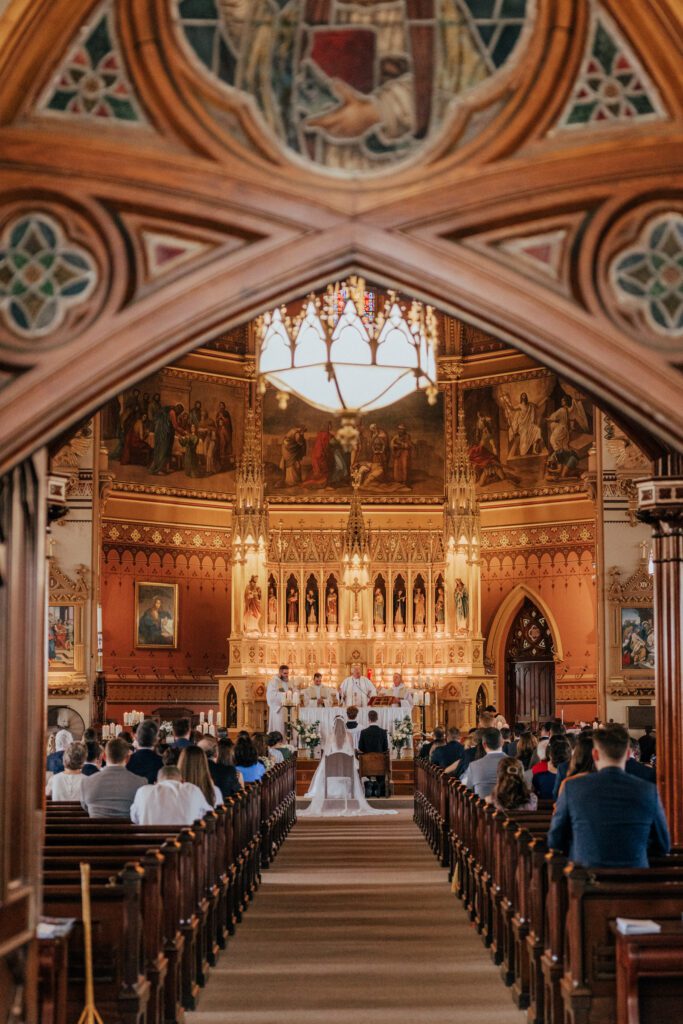 Wide shot of bride and groom standing at the alter at Quinet Saint John Garden of Our Lady in Massachusetts during wedding ceremony.