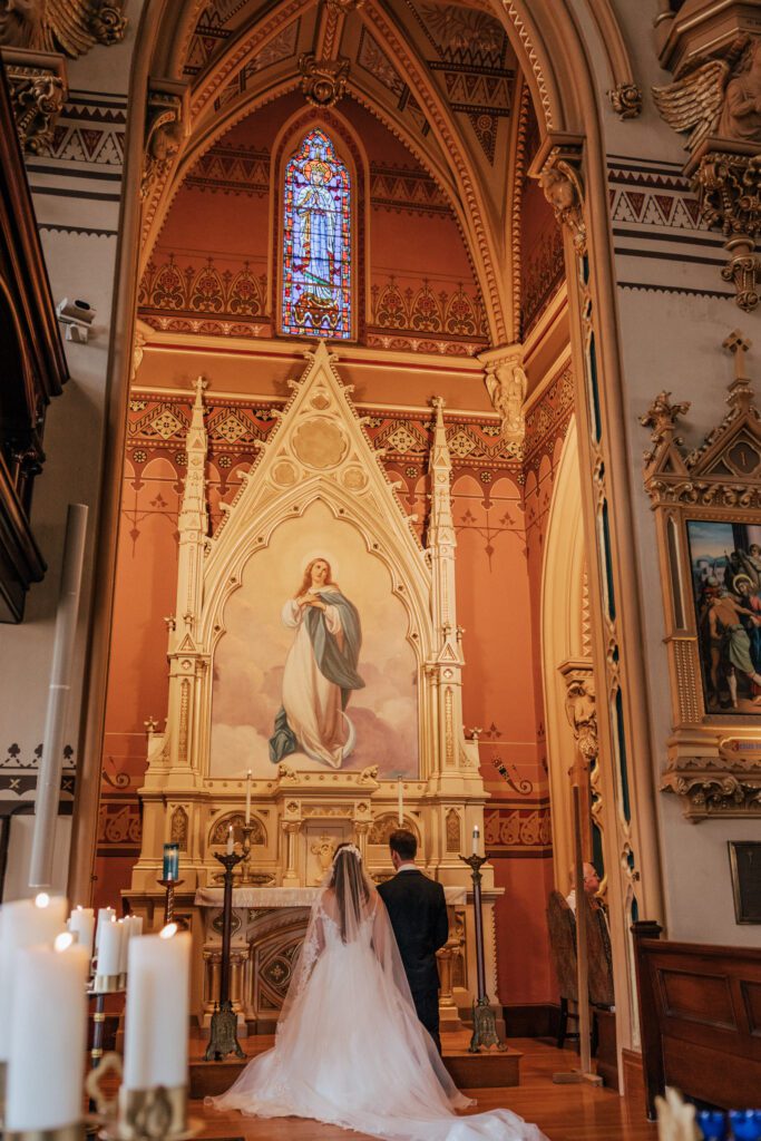 Bride and groom standing together at Quinet Saint John Garden of Our Lady in Massachusetts during wedding ceremony.