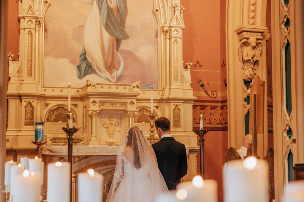Close up of bride and groom standing together at Quinet Saint John Garden of Our Lady in Massachusetts during wedding ceremony.
