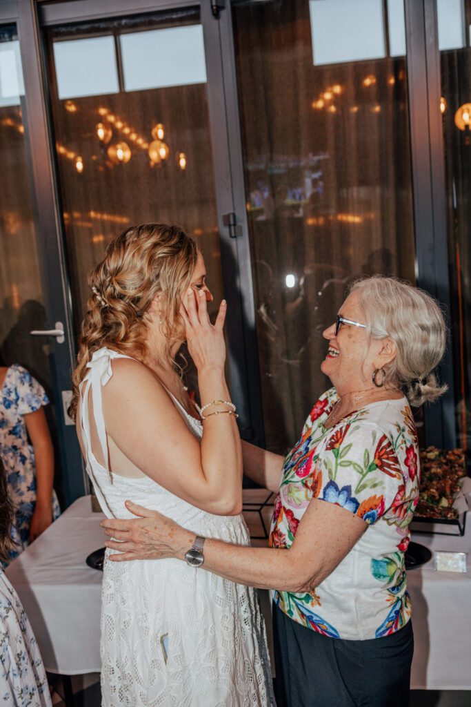 Bride and her mother laughing together at elopement reception in Massachusetts..
