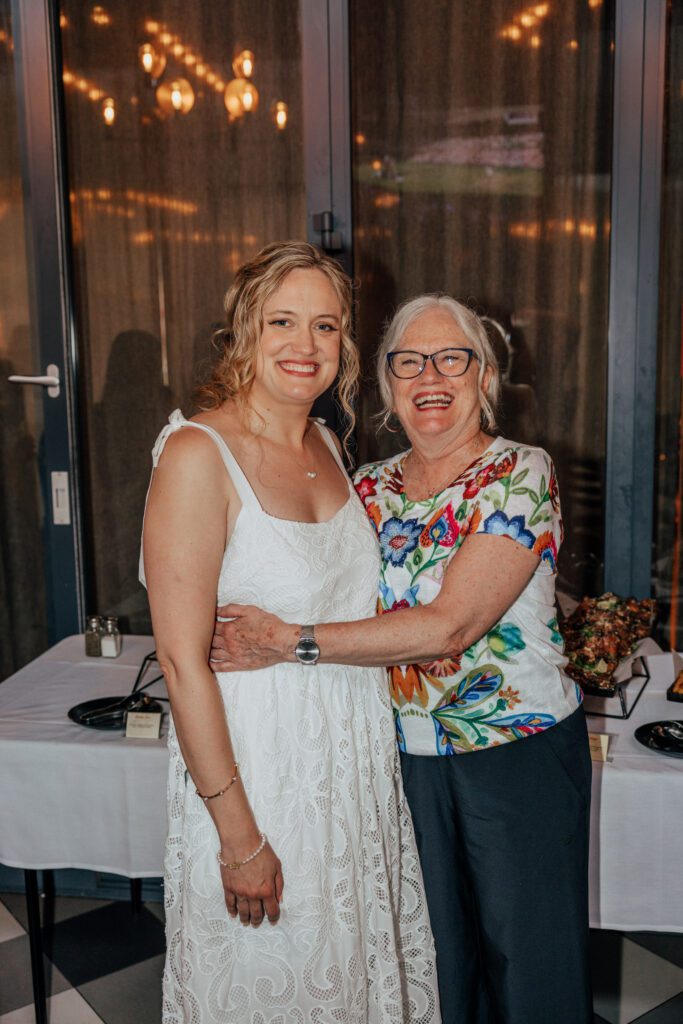 Bride and her mom hugging and smiling during elopement reception in Massachusetts..