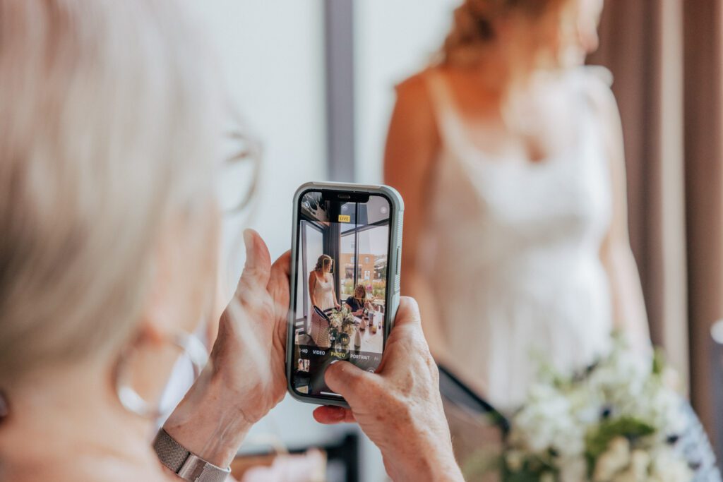 A phone taking a photo of the bride in Massachusetts.