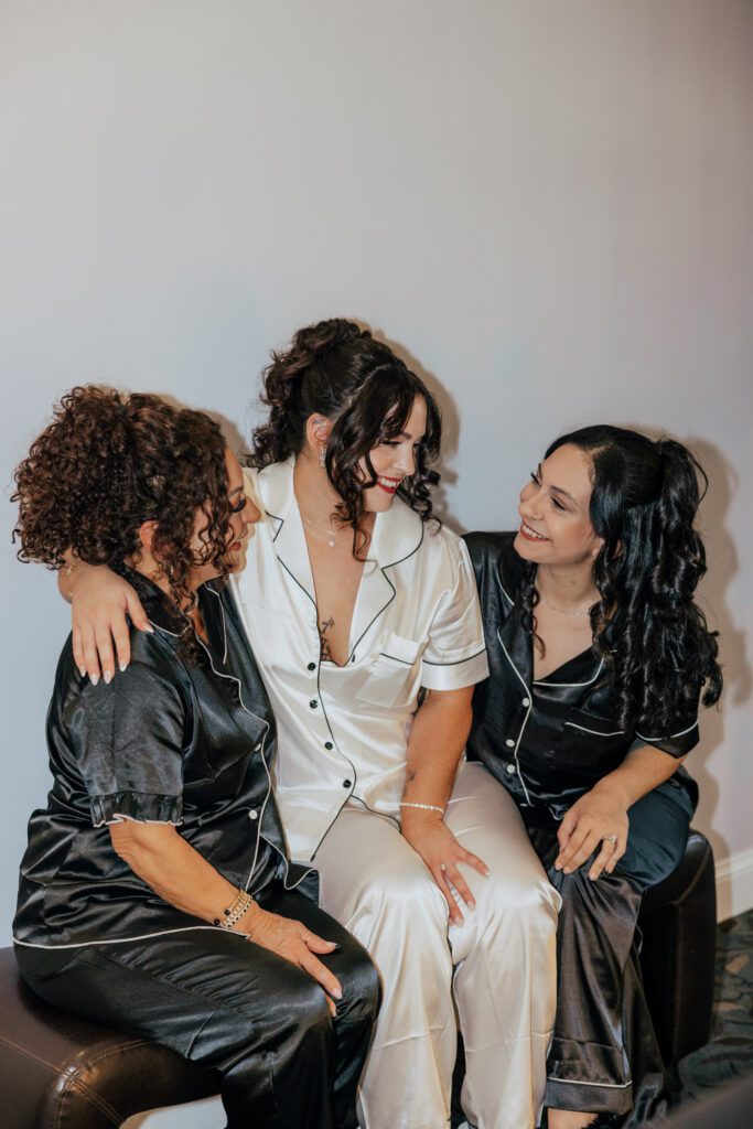 Bride sitting with her mom and sister while getting ready at Black Swan Country Club in Georgetown, Massachusetts.
