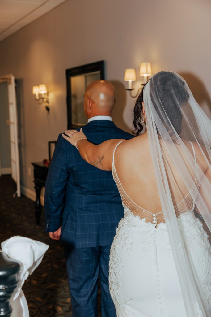 A bride touching her fathers shoulder during a first look First Look with Dad at Black Swan Country Club in Georgetown, Massachusetts.