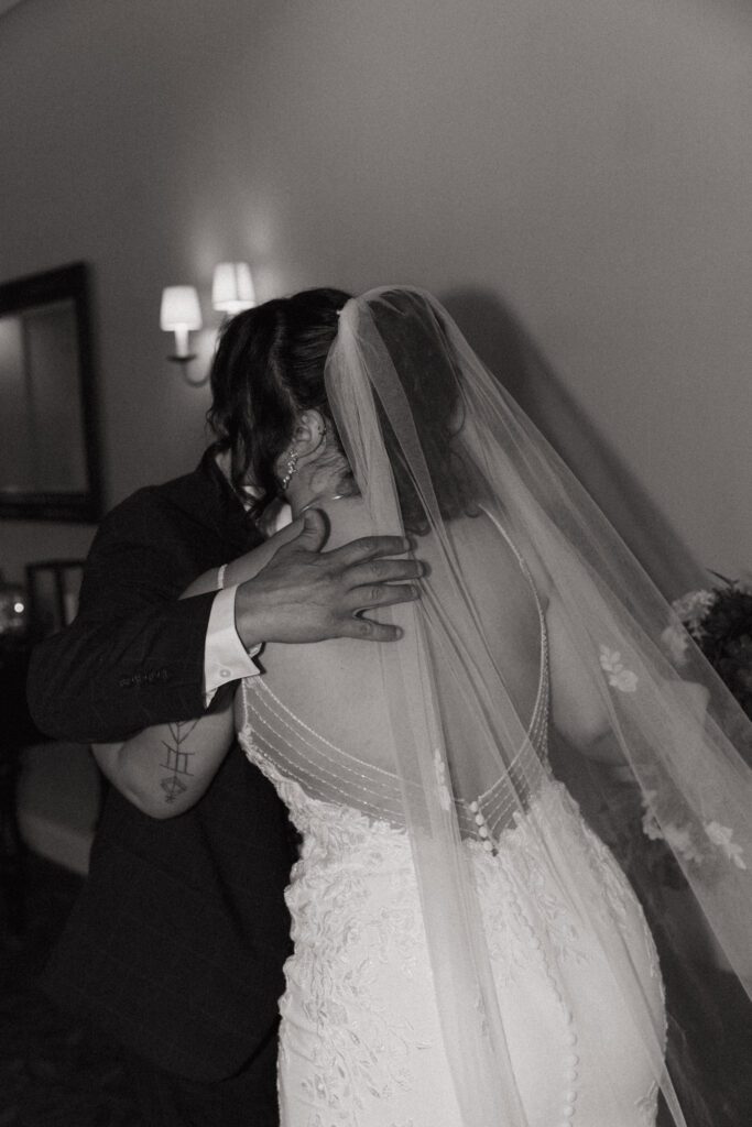 A bride and her father hug during an emotional first look at Black Swan Country Club in Georgetown, Massachusetts.