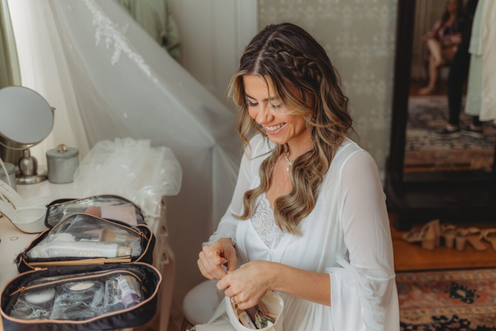 Bride laughing in a robe as she gets ready at The Evermore at Peirce Farm Estate in Topsfield, Massachusetts.