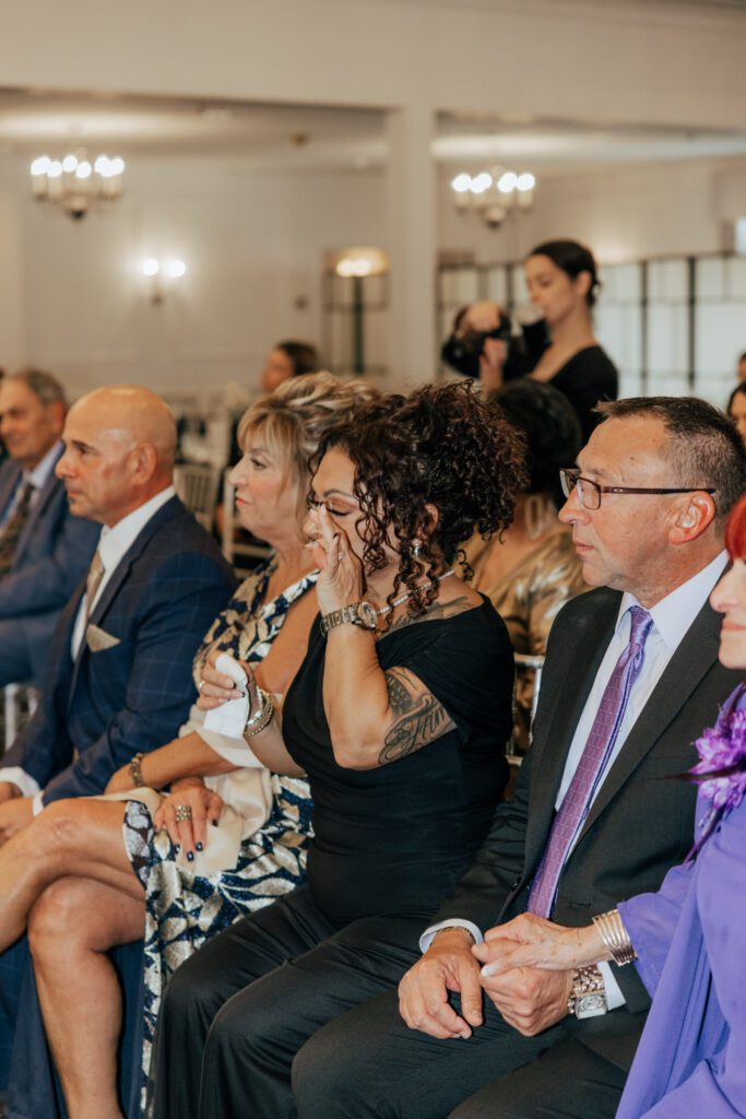 Guest cry during romantic indoor wedding ceremony at Black Swan Country Club in Georgetown, Massachusetts.