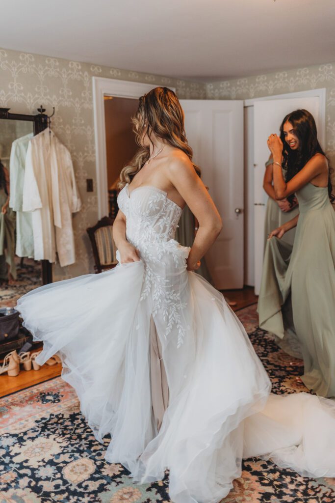 A bride spinning in her wedding dress as she gets ready at The Evermore at Peirce Farm Estate in Topsfield, Massachusetts.