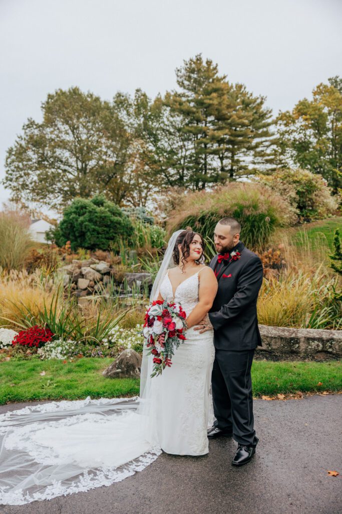 A bride and groom looking at reach other outside at their romantic wedding at Black Swan Country Club in Georgetown, Massachusetts.