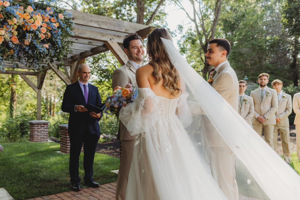 Bride walking up to groom during a romantic and whimsical outdoor wedding ceremony at Peirce Farm Estate in Topsfield, Massachusetts.