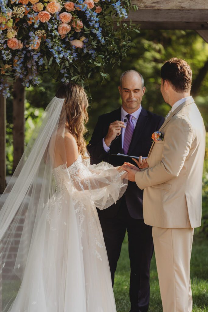 Bride and groom looking at officiant during a outdoor fairytale wedding at Peirce Farm Estate in Topsfield, Massachusetts.