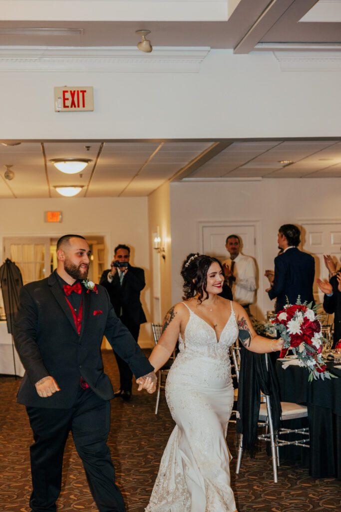 Bride and groom smiling as they enter classy wedding reception at Black Swan Country Club in Georgetown, Massachusetts.