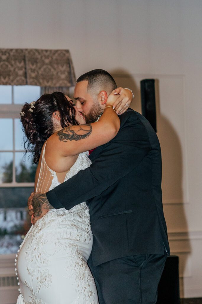 Bride and groom share a kiss during their first dance at classy wedding reception at Black Swan Country Club in Georgetown, Massachusetts.