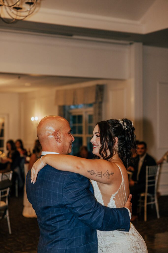 Bride and her father smiling during father daughter dance at Black Swan Country Club in Georgetown, Massachusetts.