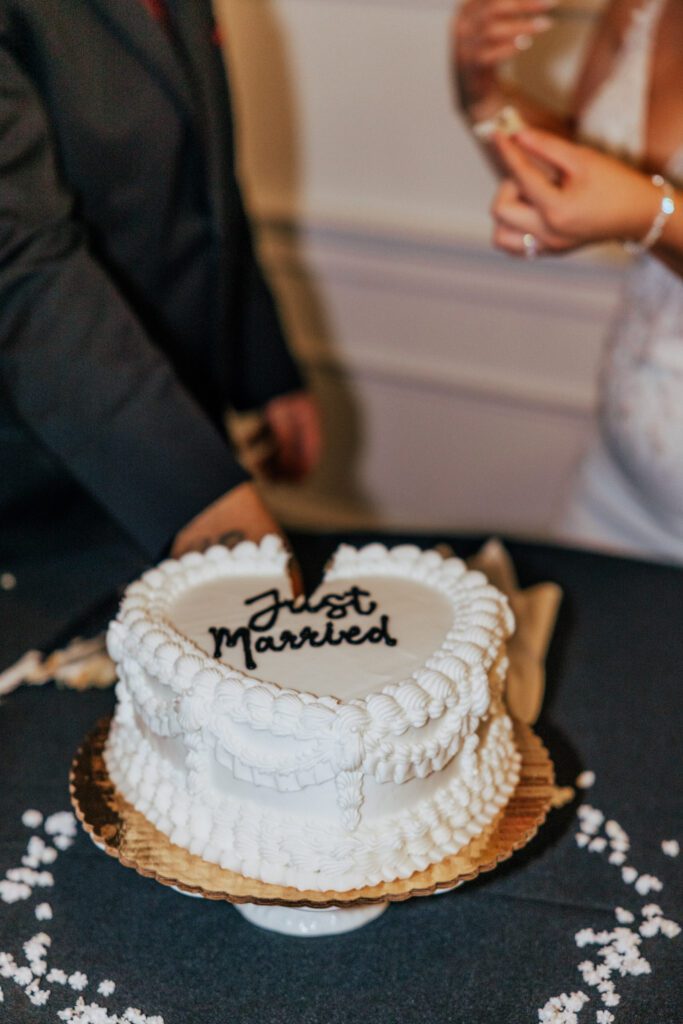 Just married heart shaped wedding cake during classy wedding reception Bride and groom laugh as they feed each other cake at Black Swan Country Club in Georgetown, Massachusetts.