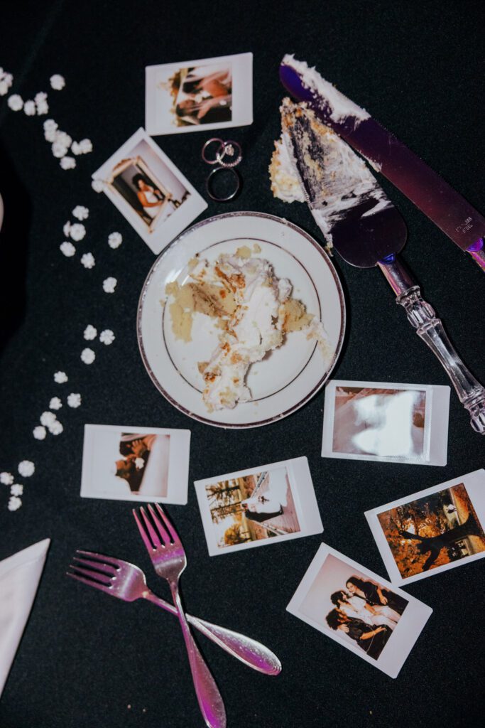Reception table with wedding rings, Polaroids, and cake at Black Swan Country Club in Georgetown, Massachusetts.
