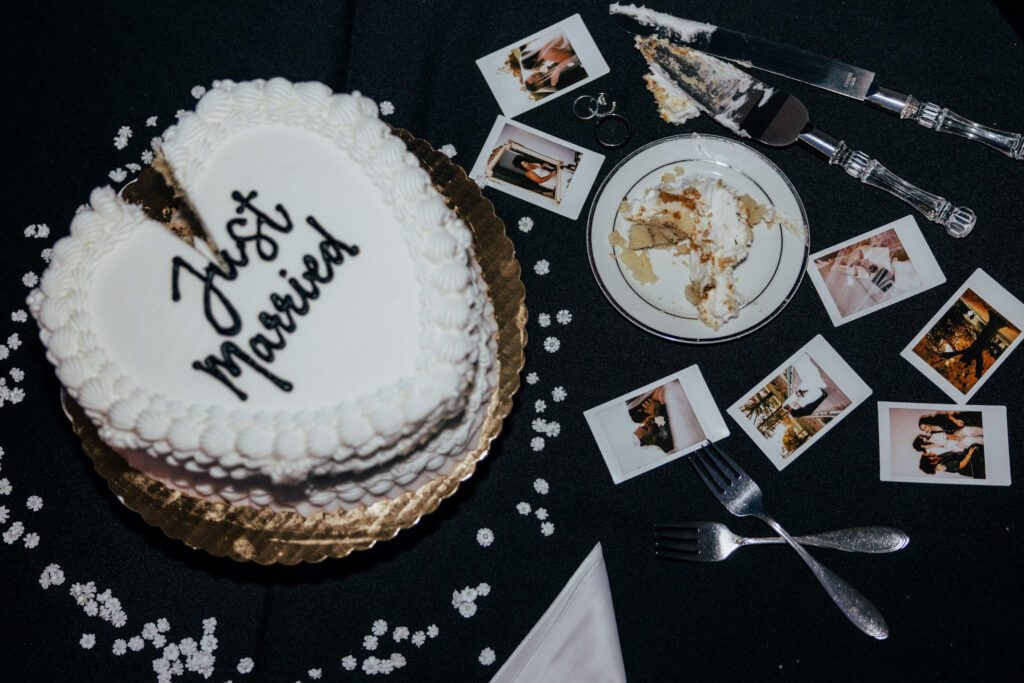 Reception table with wedding rings, Polaroids, and just married cake at Black Swan Country Club in Georgetown, Massachusetts.