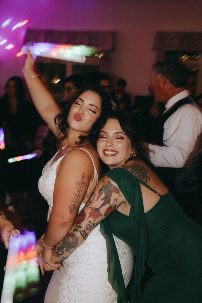 Bride and bridesmaid dancing on dance floor during classy wedding reception at Black Swan Country Club in Georgetown, Massachusetts.