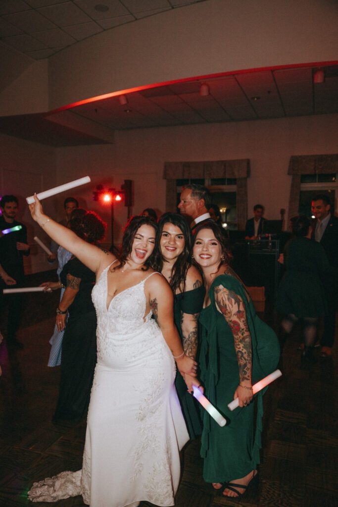A bride and her friends dancing and smiling on the dance floor during reception at Black Swan Country Club in Georgetown, Massachusetts.