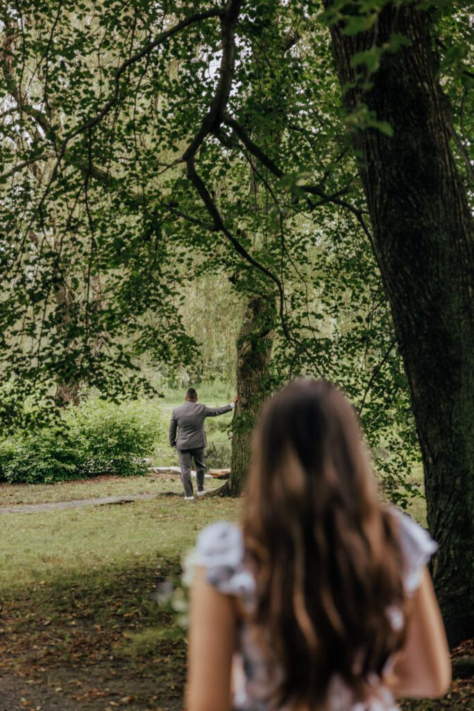 Daughter walking toward her father for a first look surrounded by greenery in the summer at Bird Park in Walpole, Massachusetts.