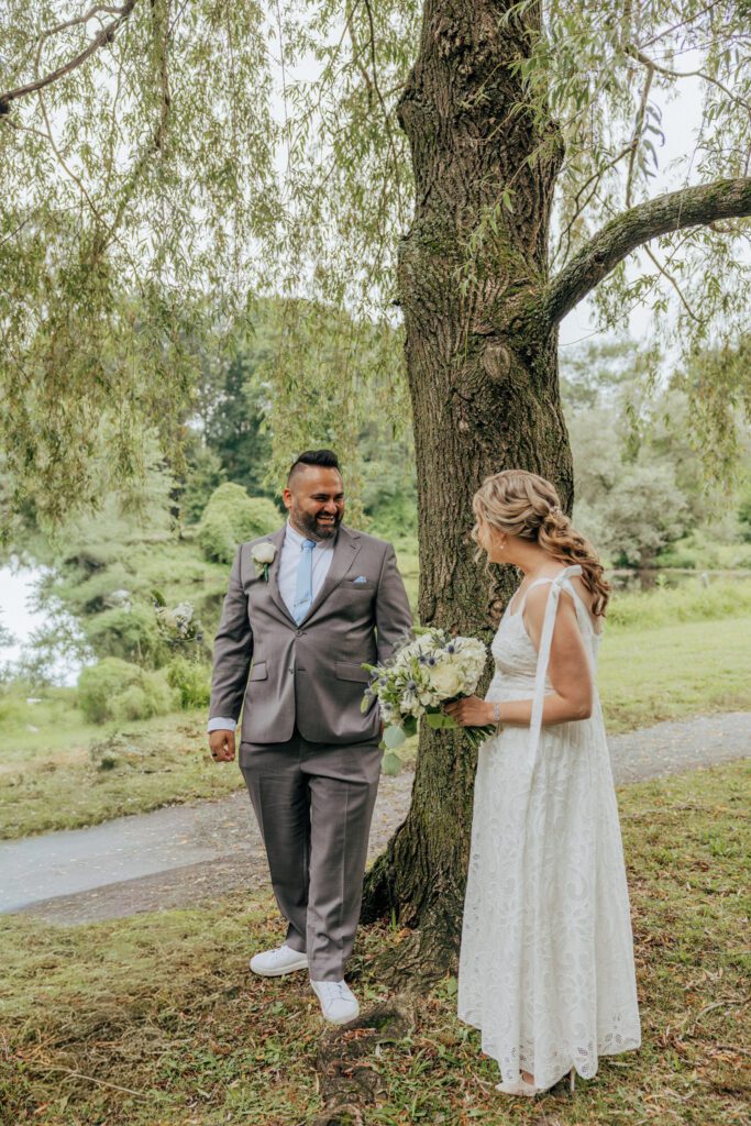 Groom turning around to see bride for the first time during first look at whimsical wedding at Bird Park in Walpole, Massachusetts.