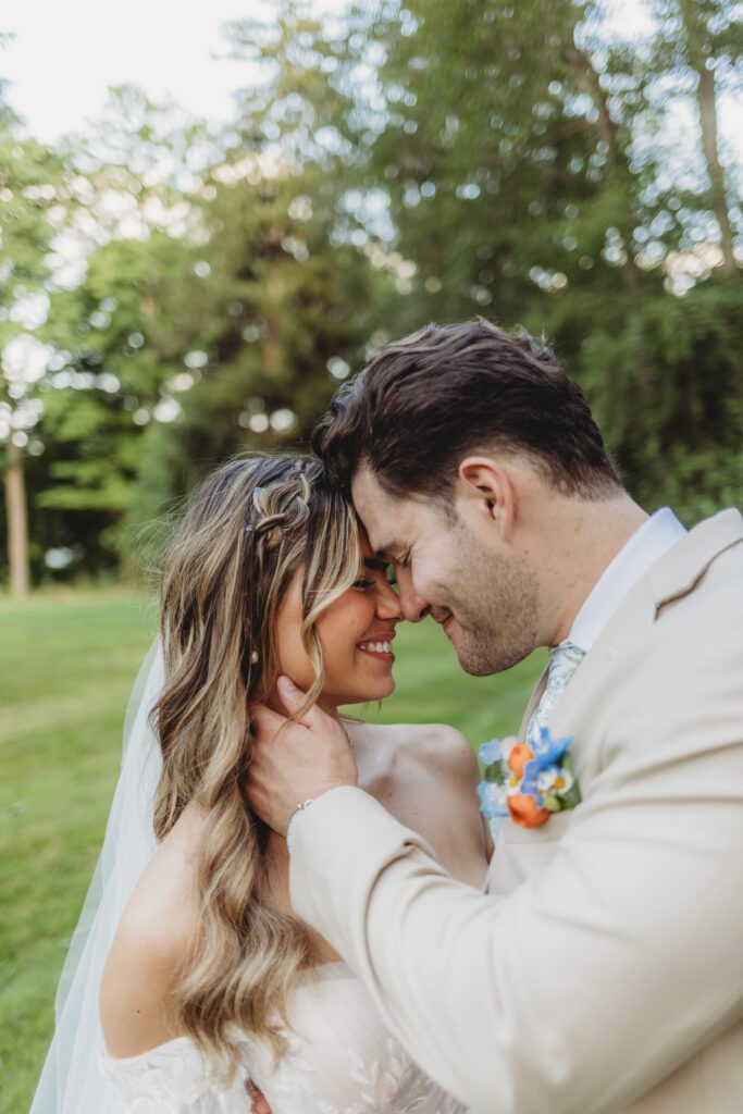Groom romantically holding bride at their whimsical summer wedding at Peirce Farm Estate in Topsfield, Massachusetts.
