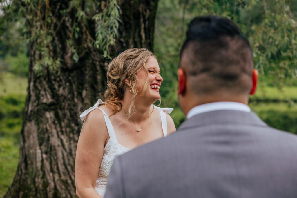 Bride laughing during outdoor summer wedding at Bird Park in Walpole, Massachusetts.
