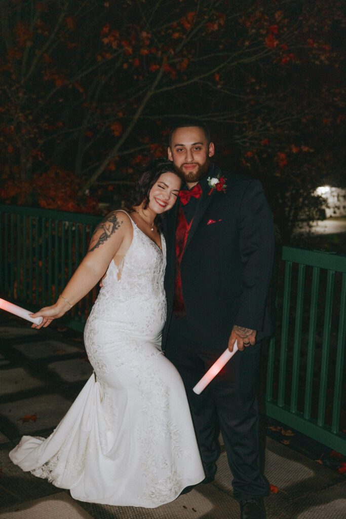 Bride and groom smiling outside on a balcony during the night at Black Swan Country Club in Georgetown, Massachusetts.