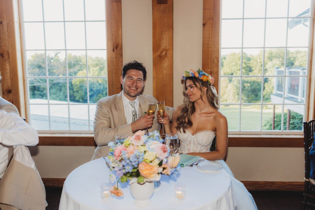 Bride and groom cheering their champagne during romantic barn reception at Peirce Farm Estate in Topsfield, Massachusetts.