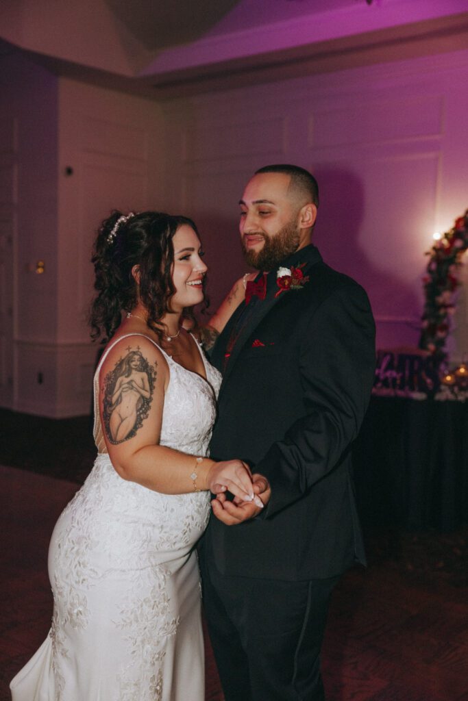 Bride and groom smiling while they dance during the reception at Black Swan Country Club in Georgetown, Massachusetts.