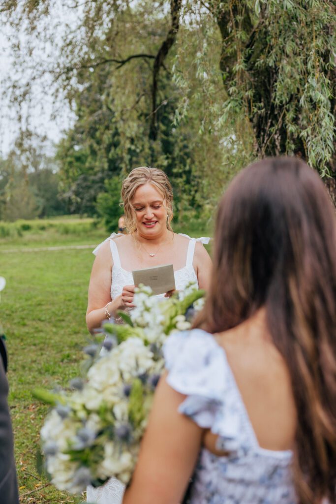 Bride reading vow to daughter during elopement ceremony at Bird Park in Walpole, Massachusetts.