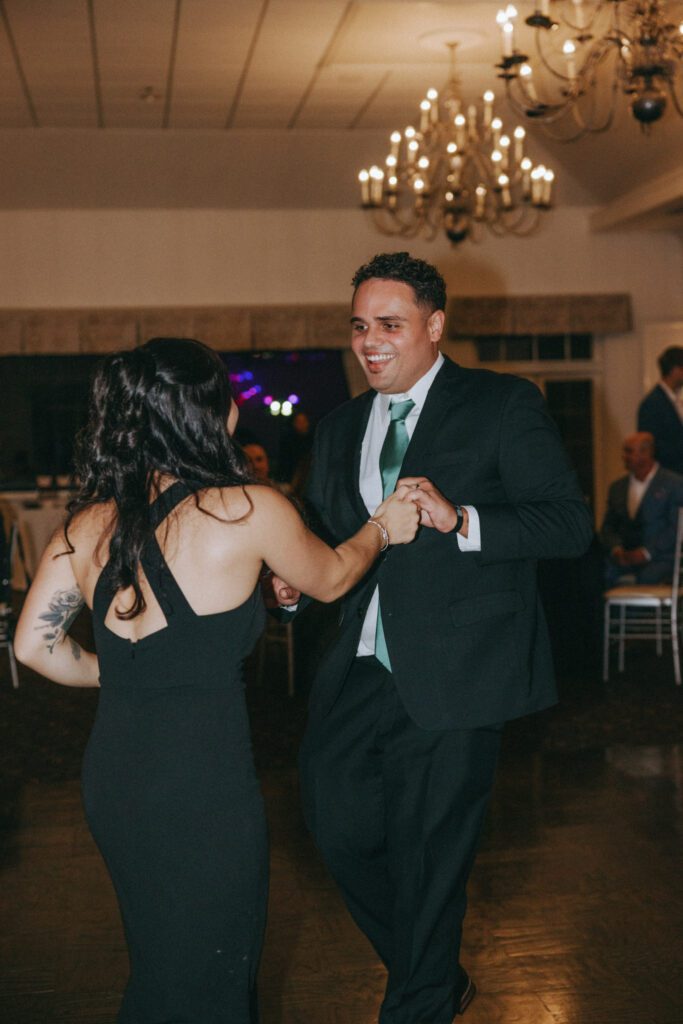 Guest smiling at each other while dancing at classy wedding reception at Black Swan Country Club in Georgetown, Massachusetts.