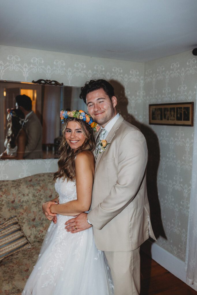 Bride and groom smiling together in the bridal suite for a direct flash photo at Peirce Farm Estate in Topsfield, Massachusetts.