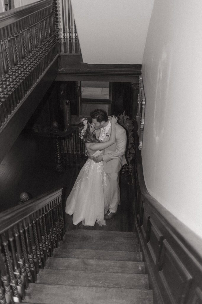 Bride and groom kissing romantically in a private stairwell at Peirce Farm Estate in Topsfield, Massachusetts.