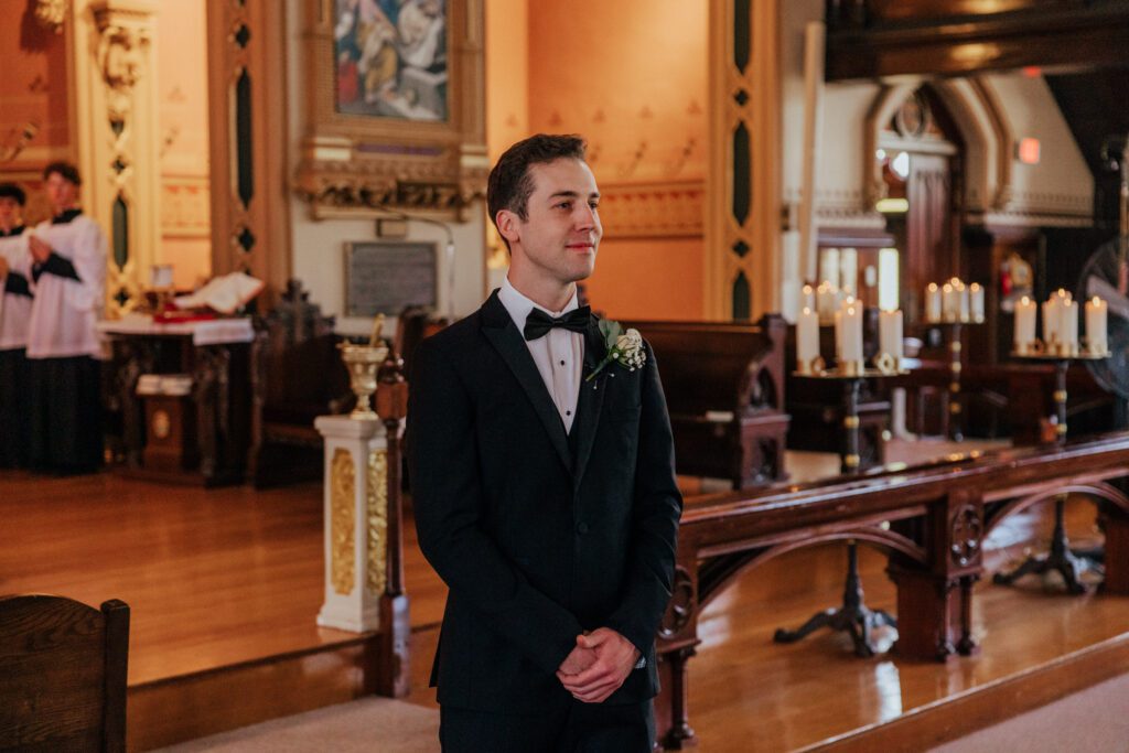 Groom smiling during summer wedding ceremony at Quinet Saint John Garden of Our Lady in Massachusetts.