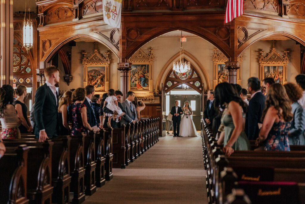 Bride and her father walking down the aisle at Quinet Saint John Garden of Our Lady in Massachusetts.