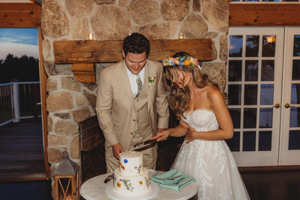 Bride and groom cutting cake at romantic barn reception at Peirce Farm Estate in Topsfield, Massachusetts.