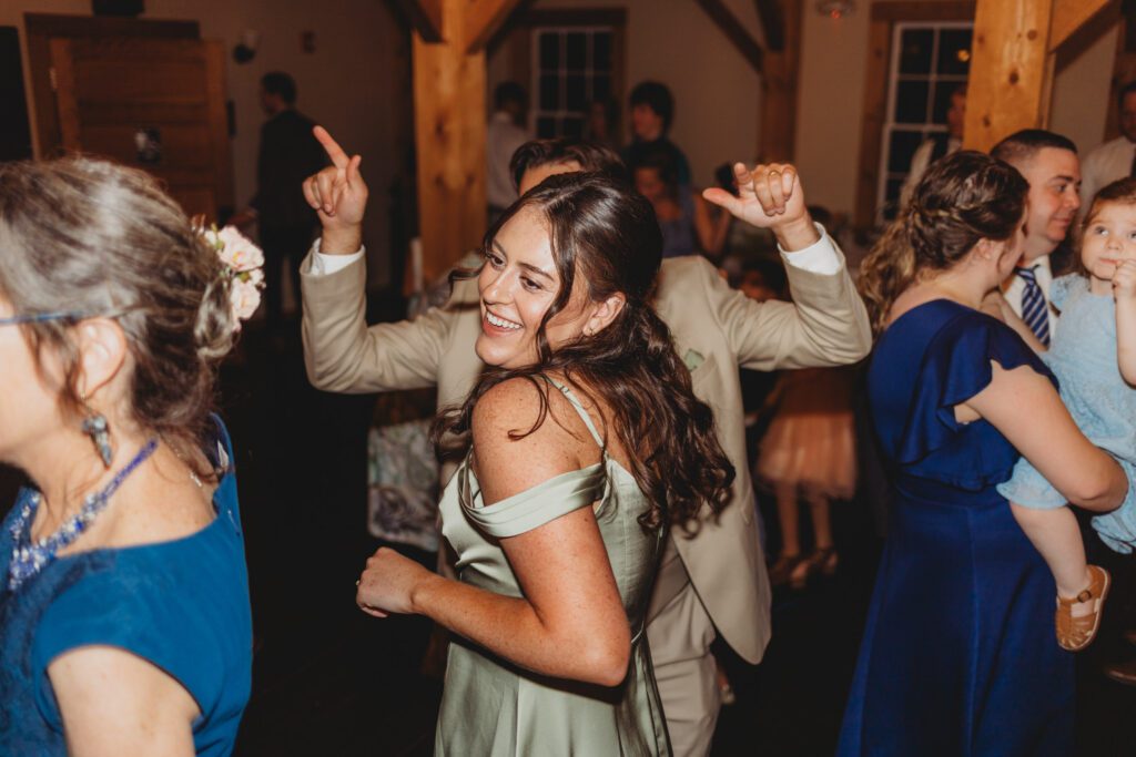 Guests dancing and smiling at romantic barn reception at Peirce Farm Estate in Topsfield, Massachusetts.