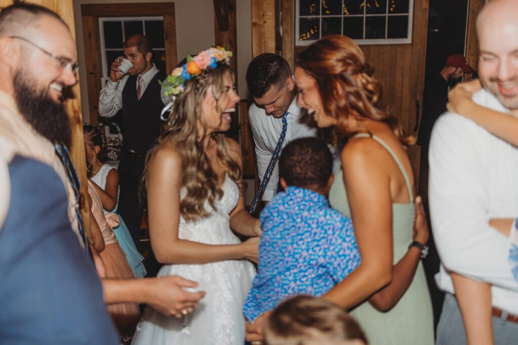 Bride and bridesmaid laughing on dance floor at Peirce Farm Estate in Topsfield, Massachusetts.