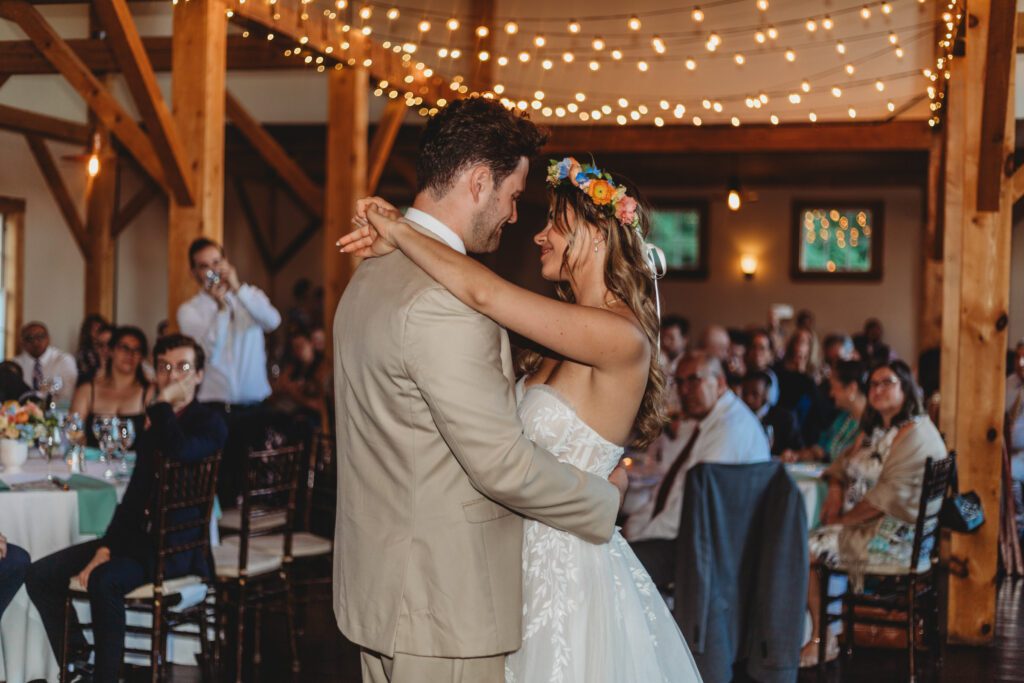 Bride and groom smiling at each other during their first dance in a romantic barn reception at Peirce Farm Estate in Topsfield, Massachusetts.