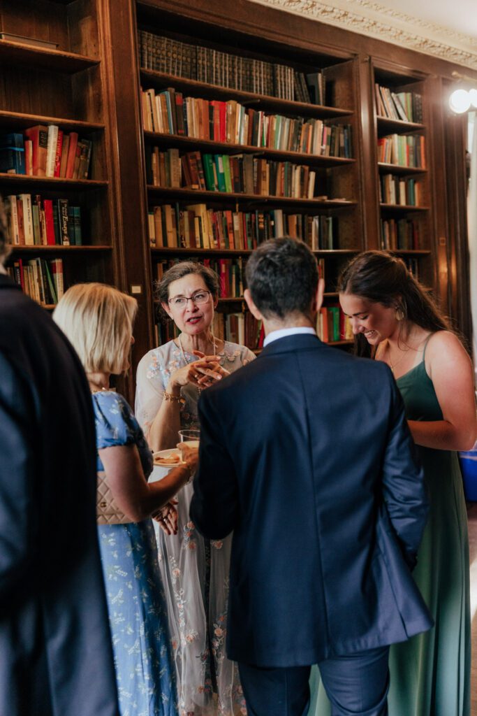 Guest talking in library during cocktail hour in Massachusetts.