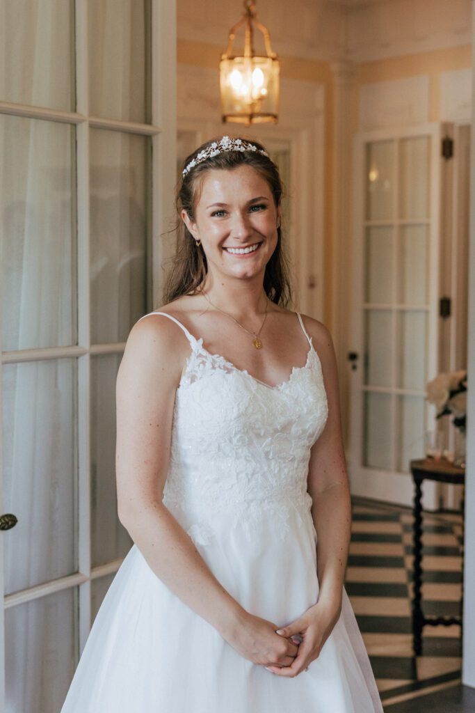 Bride smiling indoors during cocktail hour in Massachusetts.