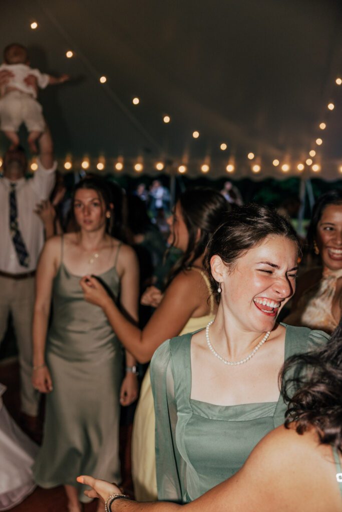 Guests dancing on dance floor and smiling during wedding reception in Massachusetts.