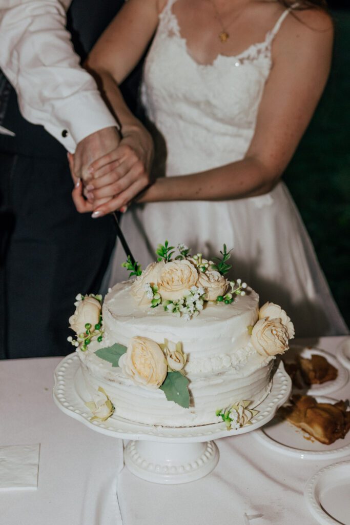 Close up of bride and groom cutting during wedding reception in Massachusetts.