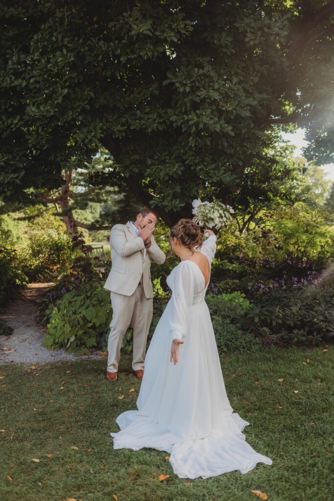 Bride and her father having a first look in a garden at New England Botanical Garden at Tower Hill in Boylston, Massachusetts.